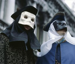 Two figures wearing masks at a carnival in Venice