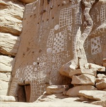 Mud reliefs and elaborate paintings on the wall of a Dogon shrine