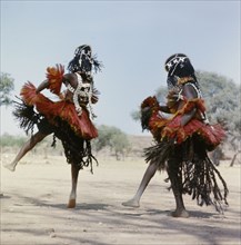 Dogon masqueraders perform in a ceremony known as a dama, which draws the souls of honoured dead away from the village and brings prestige to their families