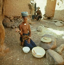 A Dogon woman gives thanks prior to commencing cooking