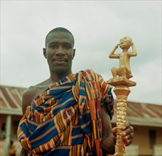 An Ashanti 'speaker' holding his staff of office, a local adaptation of staffs introduced by European traders on the Gold Coast since the C 16th