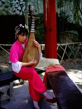 Instrument of ancient design played by a female musician dressed in Song style