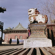 Statue of lion bearing silk threads attached by people asking favour