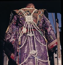 Priest dressed in brocade robes and adorned with jewellery