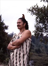A Maori man wearing traditional dress and a hei-tiki pendant
