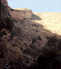 The sheer face of the Bandiagara cliffs towers above a Dogon village