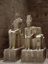 The South side of the processional colonnade of Amenophis III with seated double statues of the gods Amun and Mut