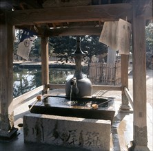 At the entrance to a shrine stands a fountain formed from a 12th century bronze Korean vessel