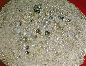 Light gleams on a vast circular mound of pearls