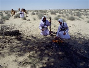 Two Bedouin lighting a fire in the desert