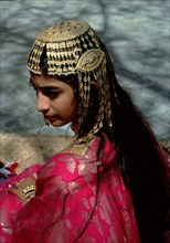 Young woman wearing an elaborate silver headdress of the type used for wedding ceremonies