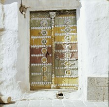 Old polychrome door set in whitewashed walls