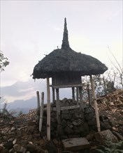 A tiny shrine, its' roof recalling the cosmic mountain, standing before the volcano Gunung Batur