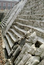 View of four Aztec stone statues reclining against a colossal stairway