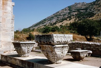 Capitals with acanthus leaf decoration in Basilica B at Philippi, with the city's ancient acropolis in the background