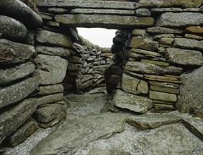 The door and stone structure of the encircling walls of House 1