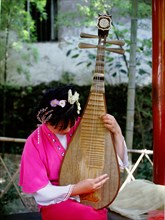 Instrument of ancient design played by a female musician dressed in Song style