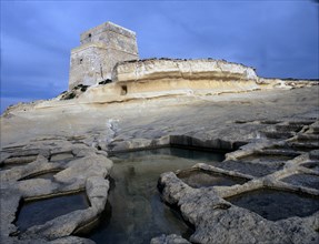 Watch tower at Xlendi, limestone formations and ancient salt pans