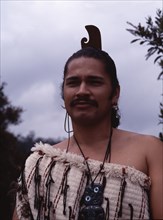 A Maori man wearing traditional dress and a hei-tiki pendant