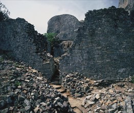 View of a stone pathway between partially restored walls from the site of great Zimbabwe