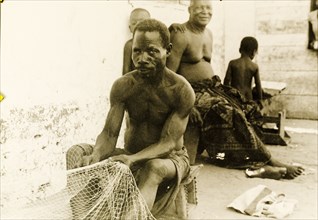 Fisherman repairing his nets, Ghana