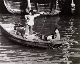 Chinese girls steer a sampan