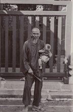 An elderly Cantonese man holds his great-grandson