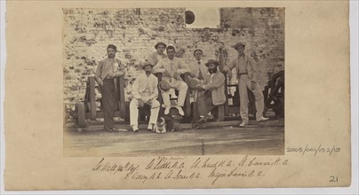 Group of men in civilian clothes pose against a wall