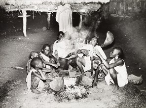 A Kikuyu family gather around a fire