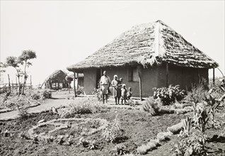 A Kikuyu family outside their home