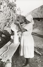 Kikuyu woman pouring milk