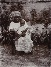 Portrait of seated African woman holding baby