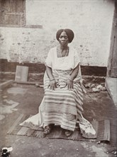 Portrait of a seated Nigerian woman wearing traditional dress
