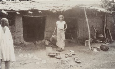 A woman selling brass pots outside her house