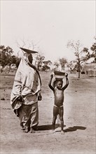 Mother and child carrying pots on their heads, Bahr-el-Ghazal