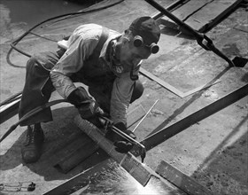 Man Using A Torch To Cut Steel