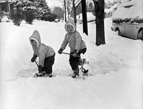 Two Children Shoveling Snow