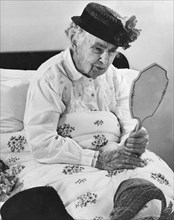 An Elderly Woman With A Mirror
