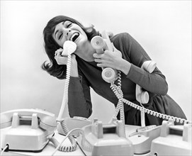 A woman tries to answer four telephones
