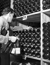 St. Moritz, Switzerland:  c. 1948.
An employee at the Palace Hotel in St. Moritz retrieves bottles