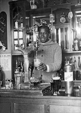 Amsterdam, Netherlands: 1928.
Uruguayan soccer star Andrade pouring a draft beer into a mug for his