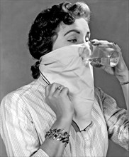 Detroit, Michigan: September 10, 1957.
A young woman tries to cure her hiccups by drinking water