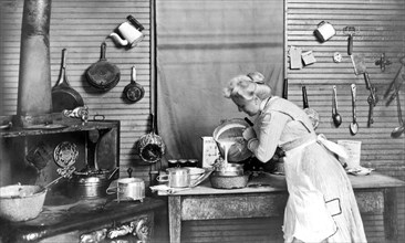 Crowley, Louisiana:   1910.
A woman pouring batter into a container.