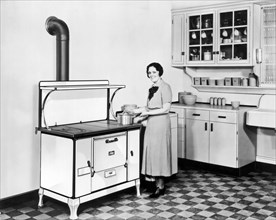 Beaver Dam, Wisconsin:  c. 1928.
A woman stands in her kitchen cooking on her Monarch stove.