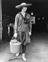 United States:  c. 1905.
A young teenage girl leaving the barn with a bucket of fresh milk.