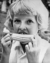 Coon Rapids, Iowa:  July 27, 1962.
A nine year old girl with a missing front tooth eats sweet corn