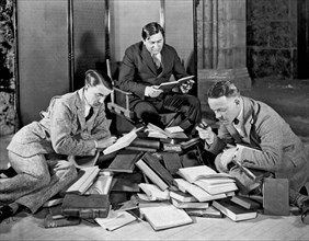 Three Men Searching Books