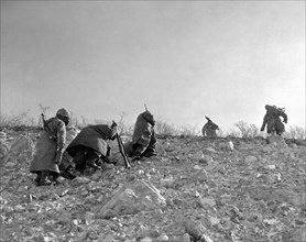 A Seventh Marine patrol fights its way up a frozen mountain side in Korea.
