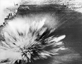 A Japanese bomb explodes on the flight deck of the USS Enterprise, killing the photographer, Phom 3/c Robert Read, but the film survived.