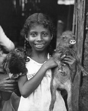 Panama:  c. 1935.
A young girl from Panama holding her pet baby peccary.